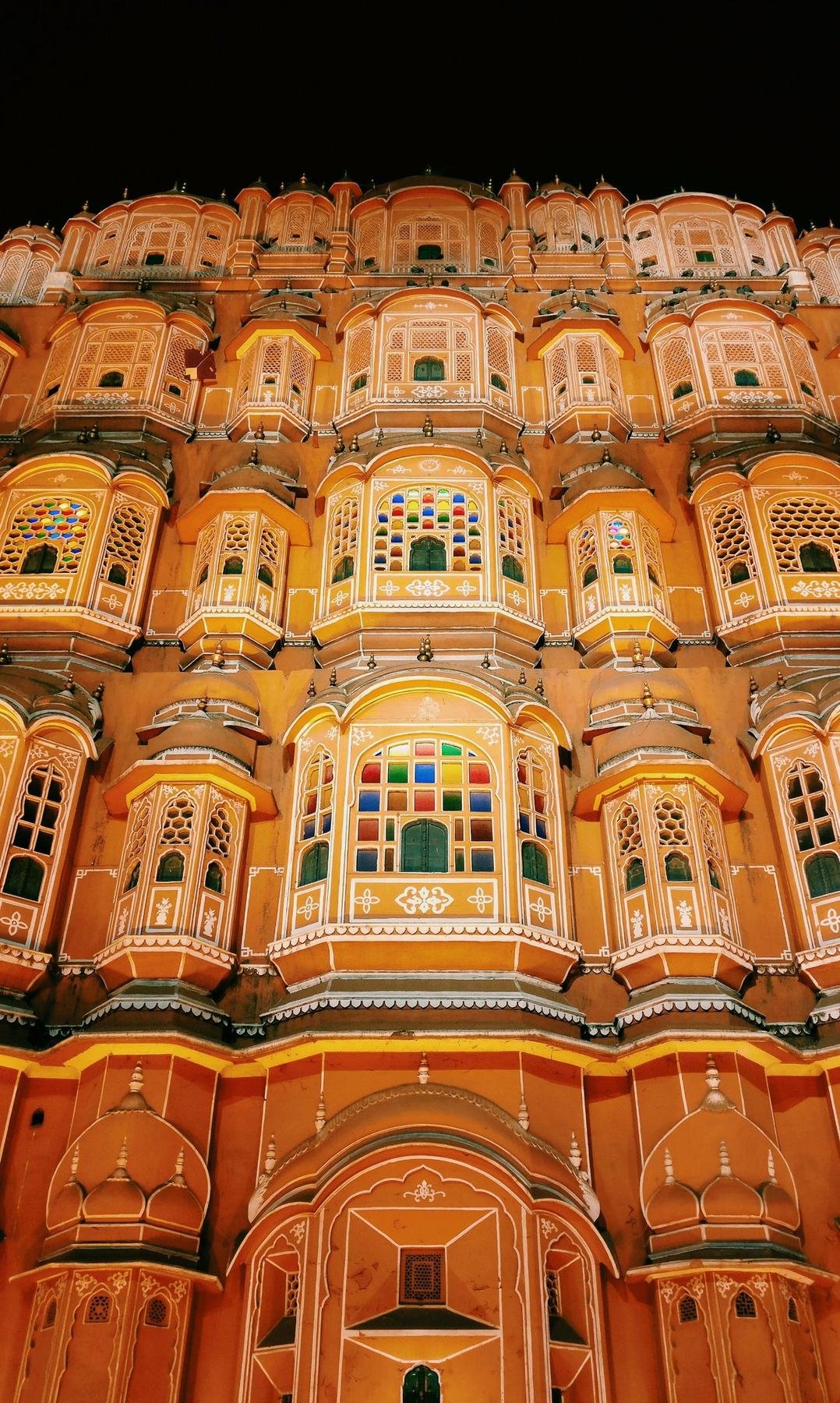 Hawa Mahal lit up at night with coloured glass windows